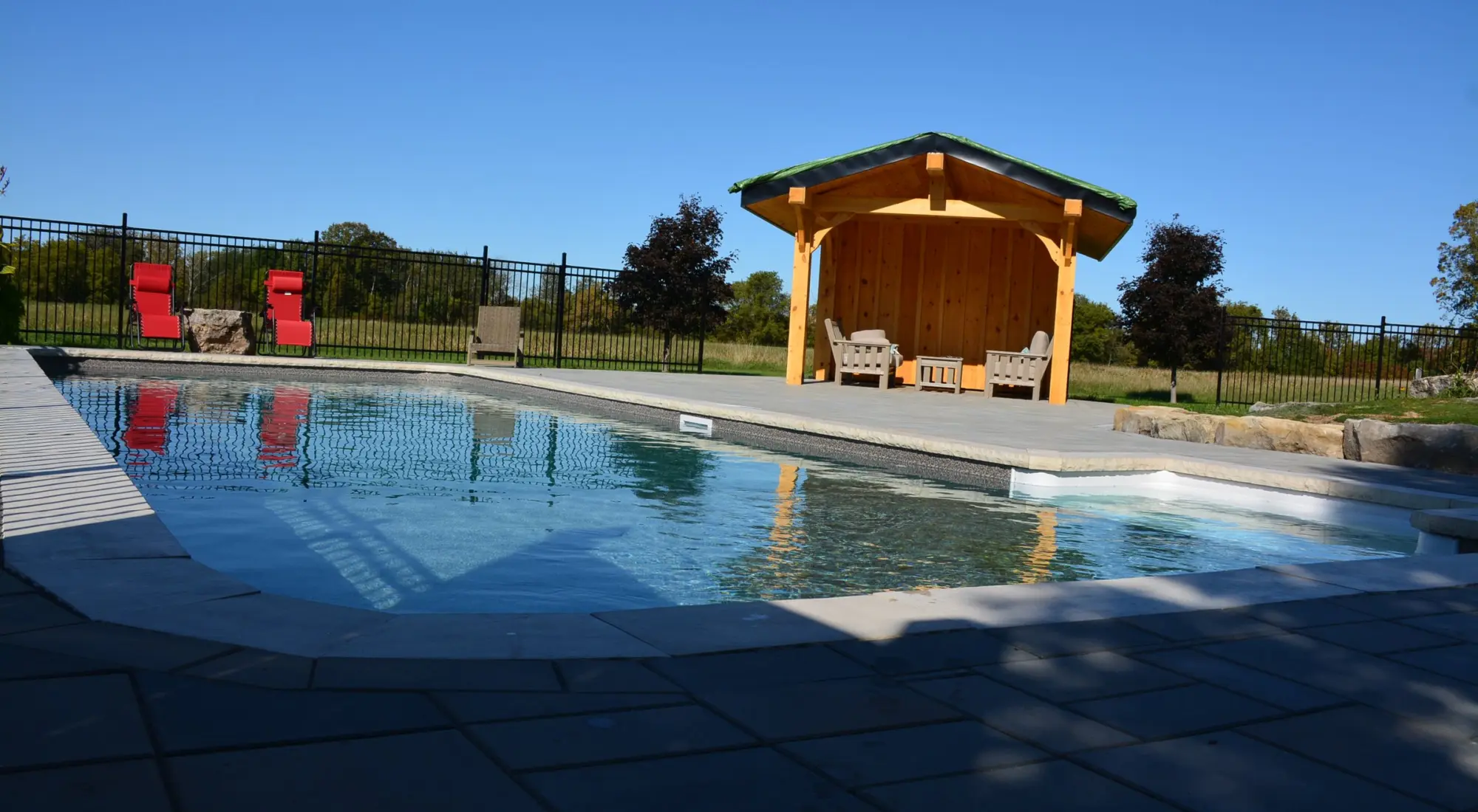 Backyard pool and cabana on a sunny day