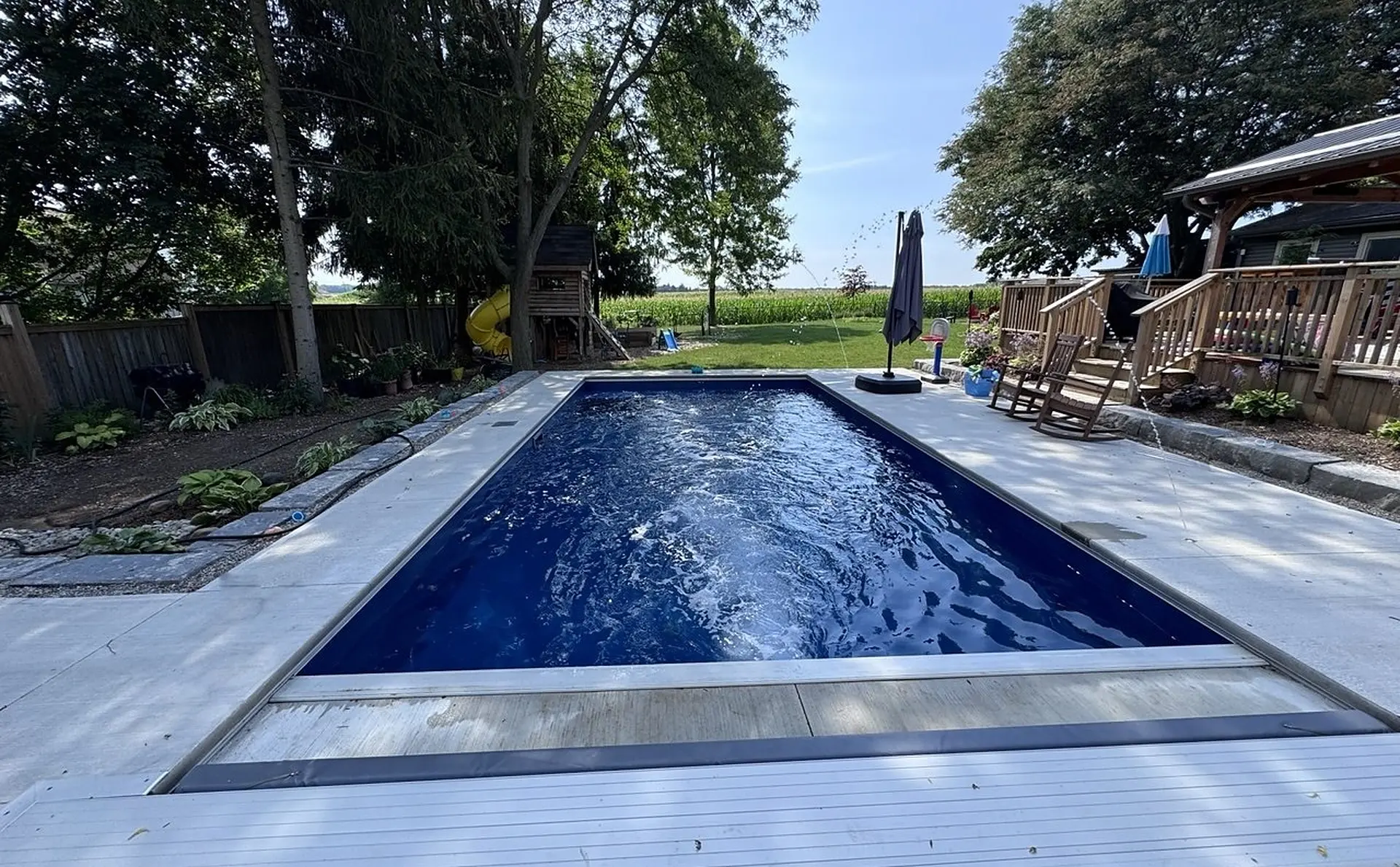 Backyard vinyl pool with concrete deck